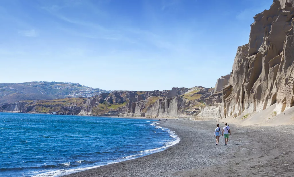 Casal em praia de Santorini