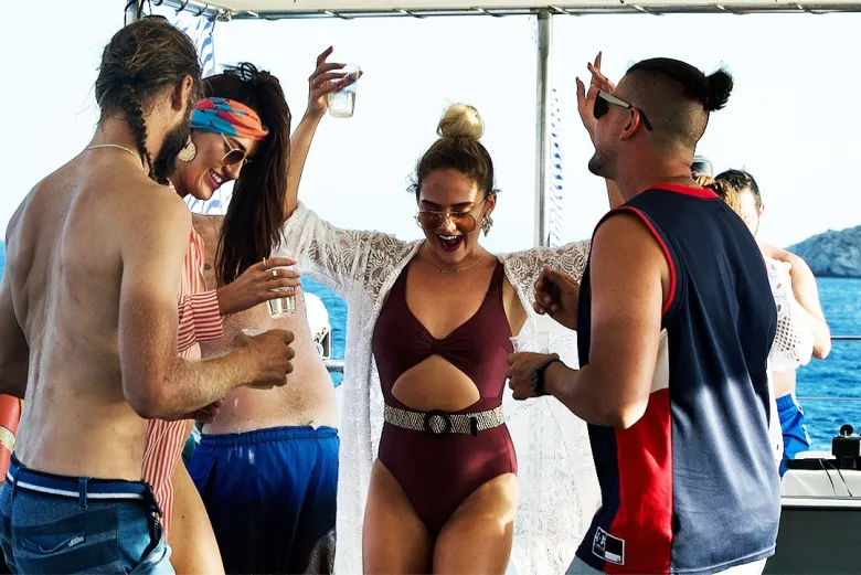 Festa no barco por Mykonos ao entardecer